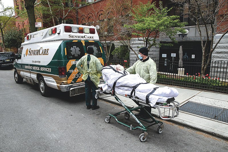 FILE - In this April 17, 2020, file photo, a patient is wheeled out of Cobble Hill Health Center by emergency medical workers in the Brooklyn borough of New York. New York Gov. Andrew Cuomo is facing blistering criticism over an internal report that found no strong link between a controversial state directive that sent thousands of recovering coronavirus patients into nursing homes and some of the nation’s deadliest nursing home outbreaks. Scientists, health care professionals and elected officials assailed the report released last week for failing to address the actual impact of the March 25 order, which by the state’s own count ushered more than 6,300 recovering virus patients into nursing homes at the height of the pandemic. (AP Photo/John Minchillo, File)