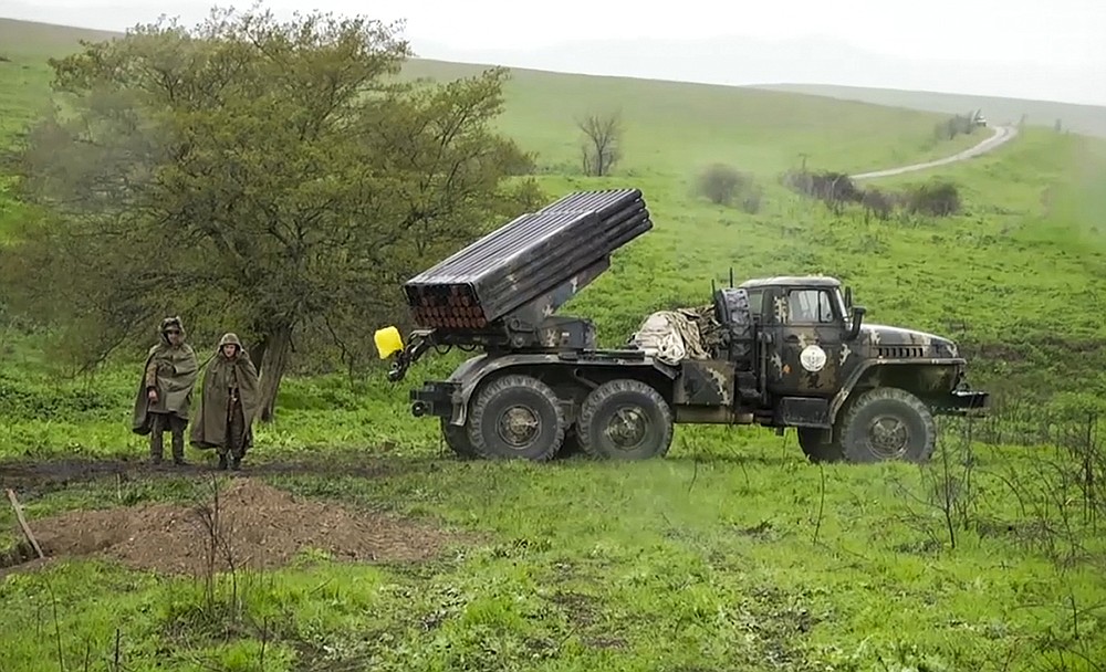In this grab taken from the Associated Press Television footage made available on Monday, April 4, 2016, Armenian soldiers pass a Grad missile launcher on Sunday, April 3, 2016, in the village of Mardakert, in the separatist region forces of Nagorno-Karabakh. Skirmishes on the volatile Armenia-Azerbaijan border escalated Tuesday, July 14, 2020 marking the most serious outbreak of hostilities between the neighbors since the fighting in 2016. (AP Photo, File)