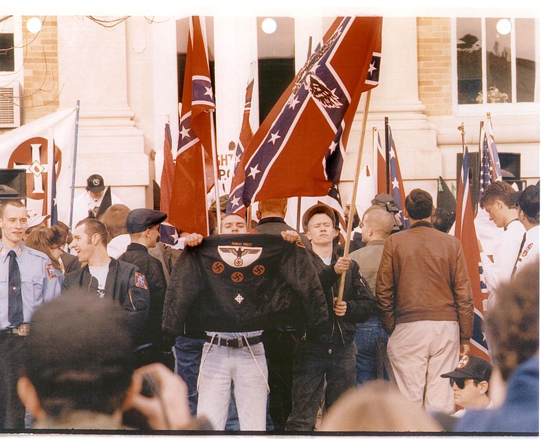 Danny Lee holds up his jacket for a photographer during a skinhead rally in this undated photo. Above the Nazi emblem are the words “Phineas Priest,” a white supremacy group. Lee, his attorneys said, eventually renounced his white supremacy beliefs but was known for his explosive temper. (Southern Poverty Law Center handout photo) 