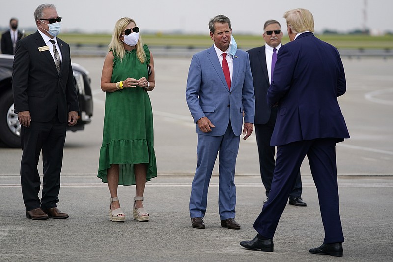 Georgia Gov. Brian Kemp, third from left, greets President Donald arrives at Hartsfield-Jackson International Airport, Wednesday, July 15, 2020, in Atlanta. (AP Photo/Evan Vucci)