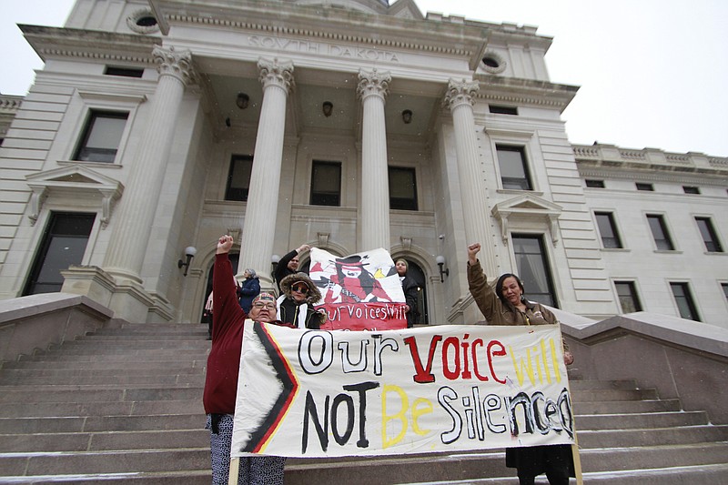 FILE - Protesters hold banners on the steps of the South Dakota Capitol in Pierre in a Tuesday, Feb. 18, 2020 file photo.Iowa, South Carolina and South Dakota recently joined Nebraska in agreeing to share driver's license information with the U.S. Census Bureau to help the Trump administration with the controversial task of figuring out the citizenship status of every U.S. resident. (AP Photo/Stephen Groves)