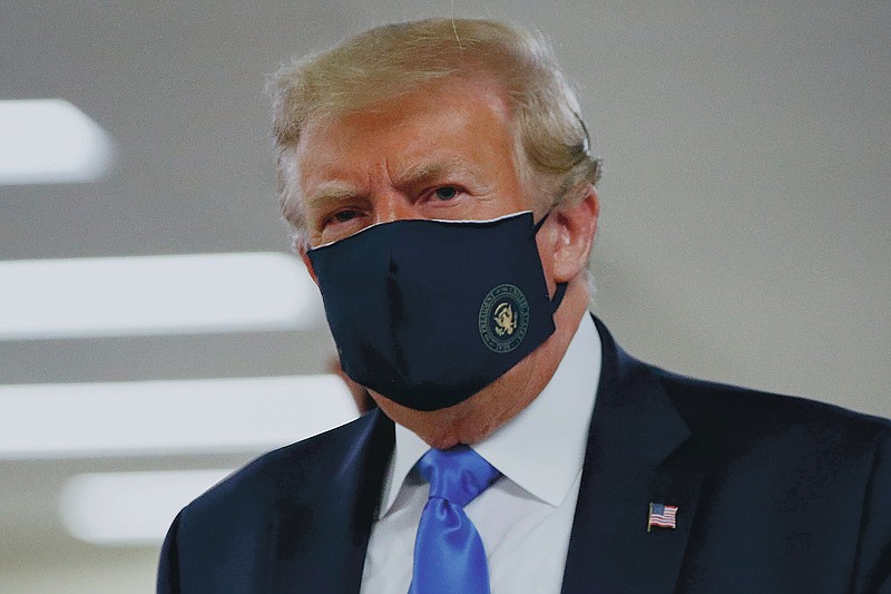 FILE - In this Saturday, July 11, 2020, file photo, President Donald Trump wears a face mask as he walks down a hallway during a visit to Walter Reed National Military Medical Center in Bethesda, Md. (AP Photo/Patrick Semansky, File)