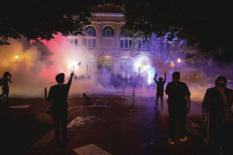 Benton County Deputies fire the first round of tear gas toward protesters June 1, 2020 after coming out of and lining up in-front of the Benton County Court House in Bentonville Arkansas. (Photo By Wesley Hitt)