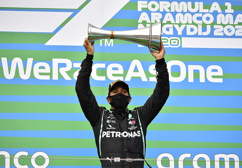 Mercedes driver Lewis Hamilton of Britain celebrates on the podium after winning the Hungarian Formula One Grand Prix at the Hungaroring racetrack in Mogyorod, Hungary, Sunday, July 19, 2020. (Joe Klamar/Pool via AP)