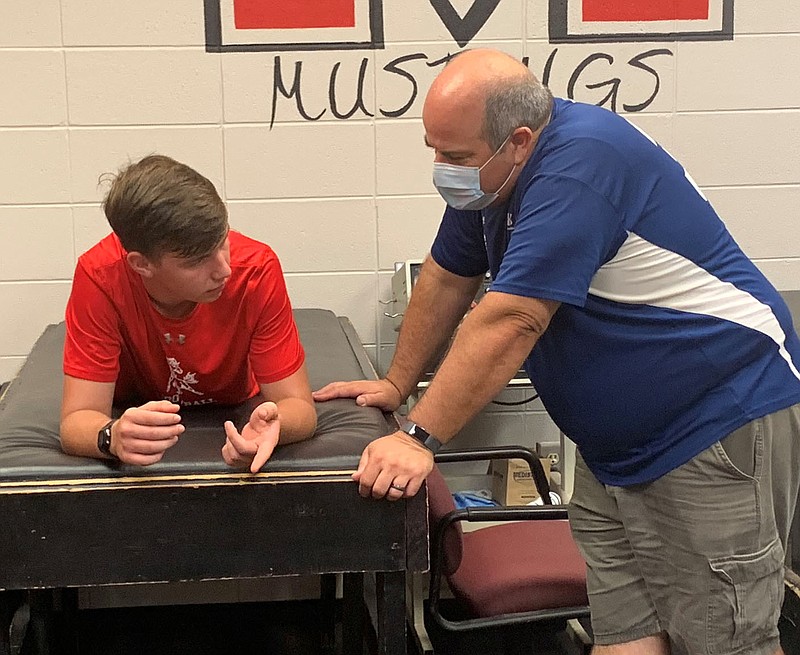 Courtesy Photo Colter Vick (left), an athlete at McDonald County High School, consults with Doug Ashton, the school's athletic trainer from Freeman Health Systems, following a morning workout at MCHS.