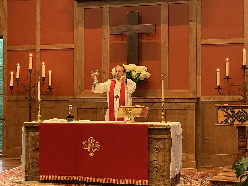 Dr. Nate Smith presents the sacramental elements at his ordination service July 15 at St. Andrew’s Church in Little Rock.
(Special to the Democrat-Gazette)