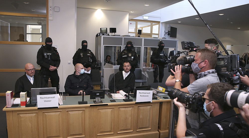 Accused Stephan Balliet, center, sits next to his lawyers Hans-Dieter Weber, left, and Thomas Rutkowski in the regional court at the beginning of the trial in Magdeburg, Germany, Tuesday, July 21, 2020. Balliet is charged with 13 crimes including murder and attempted murder, for a Yom Kippur attack on a synagogue on Oct. 9 in the eastern German city of Halle, that is considered one of the worst anti-Semitic assaults in the country's post-war history. (Ronny Hartmann/Pool via AP)