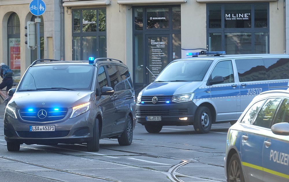 A convoy of police and justice vehicles drives with flashing blue light and siren to the Magdeburg, Germany, Tuesday, July 21, 2020. Here the trial against the assassin of Halle begins. The Federal Prosecutor's Office accuses the man of 13 crimes, including murder and attempted murder. The assassin had tried to cause a bloodbath in the synagogue in Halle on October 9, 2019, the highest Jewish holiday Yom Kippur. (Sebastian Willnow/dpa via AP)