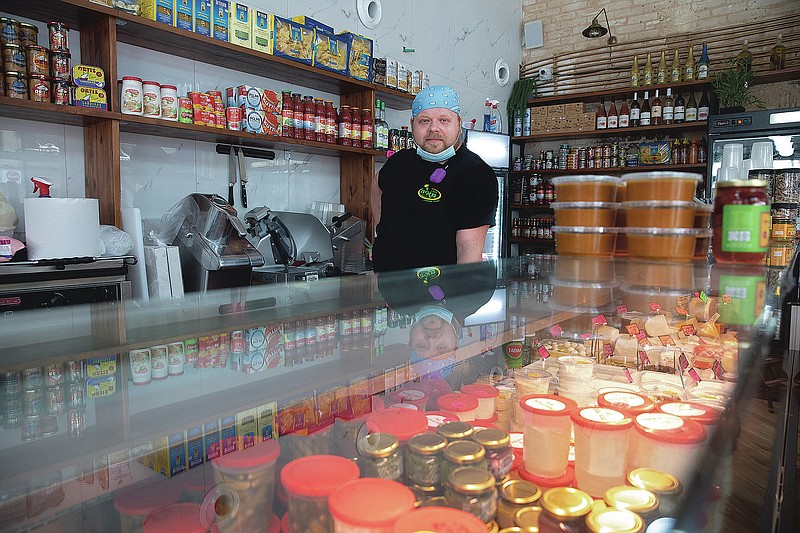 Cijay Brightman poses for a photo in Tel Aviv, Israel, Monday, July 13, 2020. A year ago, Brightman was doing sound and lighting for a Madonna performance in Israel. Now, after the coronavirus wiped out live events, he's making sandwiches, slicing cheese and serving customers at a Tel Aviv deli. (AP Photo/Sebastian Scheiner) story.lead_photo.caption
