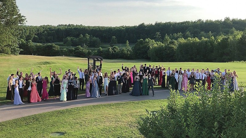In this Saturday, July 18, 2020, image provided by Carol Justic, recent Bedford High School graduates and students pose for a photo at their outdoor prom outdoor at the Stonebridge Country Club in Goffstown, N.H., organized during the coronavirus pandemic.  Amid the debate over how to reopen schools safely, some teens and parents are organizing private proms to replace events canceled because of the coronavirus.  (Carol Justic via AP)