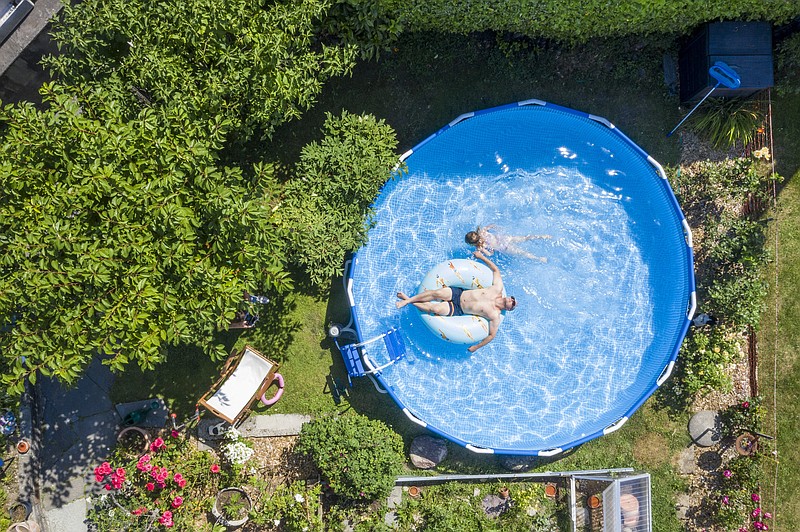 A man and his daughter enjoy a dip in their backyard pool in Zurich, Switzerland, July 30.
(AP file photo/Keystone/Ennio Leanza)