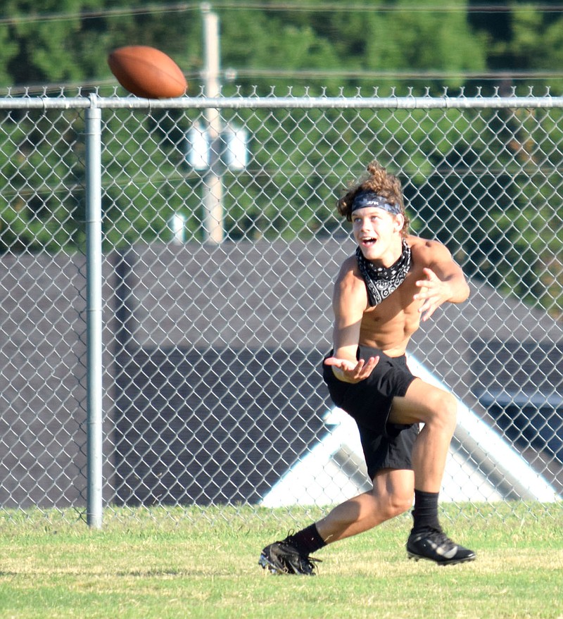 Westside Eagle Observer/MIKE ECKELS

A Lion receiver keeps a watchful eye on the ball as it flies toward him during the July 22 light practice session on the practice field the Gravette Lions sports complex. No word on the future of Arkansas High School football as of yet.