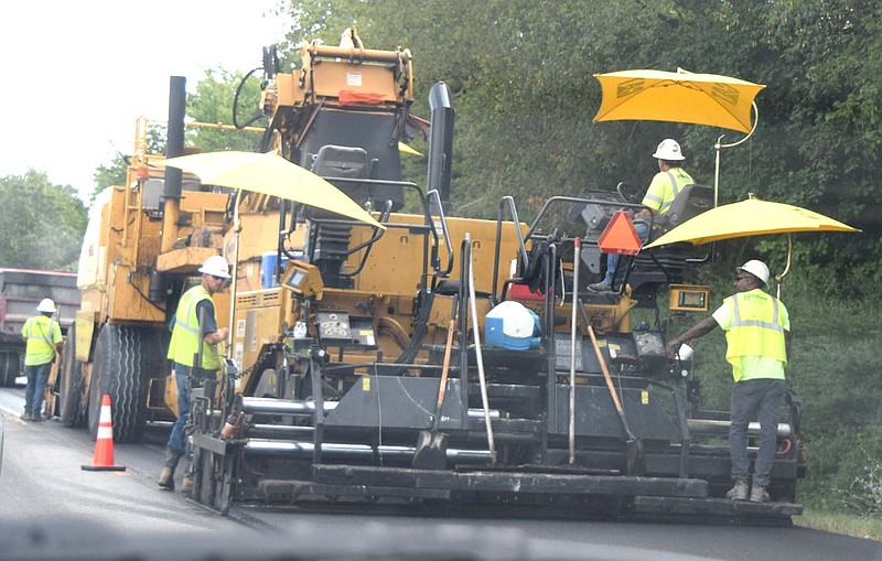 Westside Eagle Observer/MIKE ECKELS

A portion of Arkansas Highway 59 across from Grand Savings Bank in Gentry receives a fresh coat of asphalt from a giant paving machine July 23. Over the next several months travelers on Arkansas 59 will experience long delays as the Arkansas Highway Transportation Department works on the old highway resurfacing project from Gentry to the Arkansas /Missouri boarder.