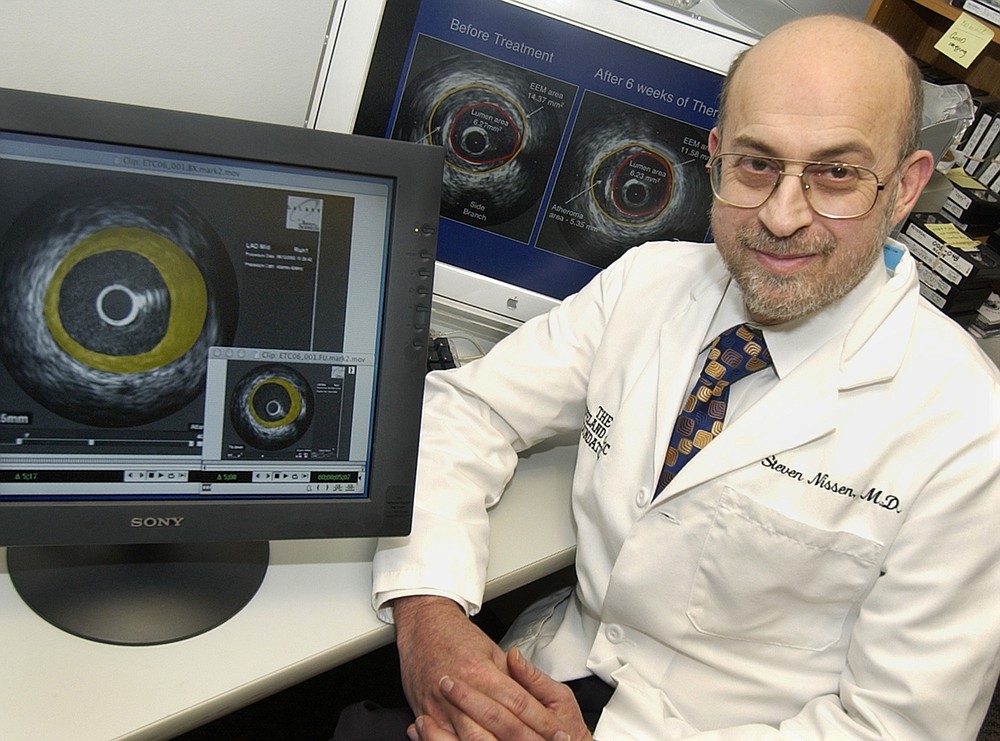 FILE - In this  Jan. 16, 2004 file photo, Dr. Steven Nissen poses for a photo in his laboratory at the Cleveland Clinic beside screens with ultrasound images of coronary arteries in Cleveland, Ohio. Nissen, who has been a frequent adviser to the Food and Drug Administration has been very critical of the Trump administration’s approach to finding remedies for COVID-19, comparing it to “… throwing spaghetti at the wall and seeing what sticks. I consider trials like (the famotidine/Pepcid trial) to be largely a waste of time and money when they’re very unlikely to show positive results.” (AP Photo/Amy Sancetta)