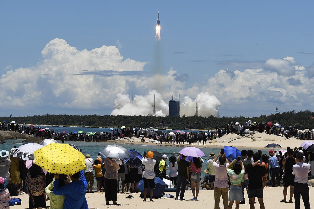 In this photo released by China's Xinhua News Agency, spectators watch as a Long March-5 rocket carrying the Tianwen-1 Mars probe lifts off from the Wenchang Space Launch Center in southern China's Hainan Province, Thursday, July 23, 2020. China launched its most ambitious Mars mission yet on Thursday in a bold attempt to join the United States in successfully landing a spacecraft on the red planet. (Yang Guanyu/Xinhua via AP)