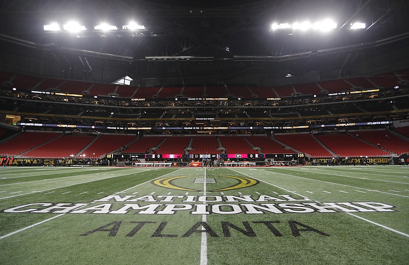 FILE - In this Jan. 8, 2018, file photo, the championship logo is seen on the field at Mercedes-Benz Stadium before the NCAA college football playoff championship game between Georgia and Alabama in Atlanta. There are more bowl games scheduled for the coming season than ever before in major college football: 42, not including the College Football Playoff championship. College football leaders are in the process of piecing together plans to attempt to play a regular season during the COVID-19 pandemic. If it is even possible, everyone anticipates there will be disruptions, added expenses and loads of stress just to get through it.(AP Photo/David Goldman)