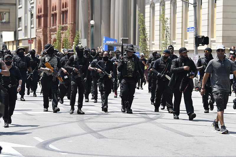 Armed members of the "NFAC" march through downtown Louisville, Ky., toward the Hall of Justice on Saturday, July 25, 2020. Hundreds of activists demanded justice for Breonna Taylor during the demonstrations in her hometown that drew counter-protesters from a white militia group. Taylor, a 26-year-old EMT, was fatally shot when police officers burst into her Louisville apartment using a no-knock warrant during an investigation. (AP Photo/Timothy D. Easley)