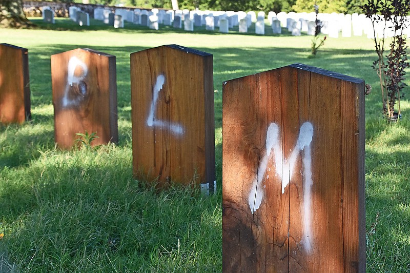 Defaced headstones sit around the Confederate monument on Friday, July 26, 2020 at Oakland Cemetery in Little Rock. 
(Arkansas Democrat-Gazette/Staci Vandagriff)