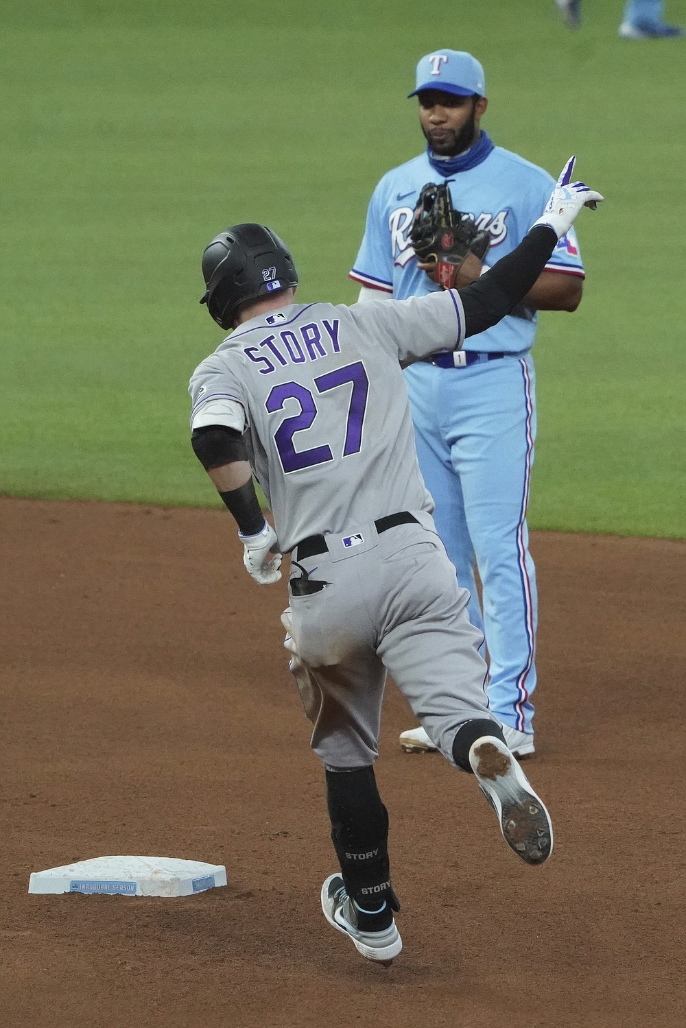 Colorado Rockies' Trevor Story (27) rounds second base past Texas Rangers shortstop Elvis Andrus after hitting a home run in the fourth inning of a baseball game Sunday, July 26, 2020, in Arlington, Texas. (AP Photo/Louis DeLuca)