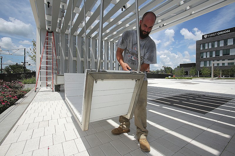 John Morris with Alessi Keyes Construction puts up a swing in the Argenta Plaza on Thursday, July 23, 2020, in North Little Rock. 
(Arkansas Democrat-Gazette/Thomas Metthe)