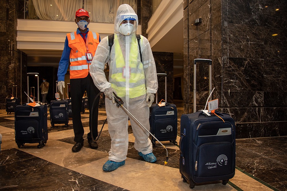 In this July 26, 2020, photo, the luggage of pilgrims is sanitized in a hotel lobby in Mecca ahead of the annual hajj pilgrimage. The Islamic pilgrimage has been dramatically downsized this year with only a few thousand residents of Saudi Arabia permitted to take part due to concerns over the coronavirus. (Saudi Ministry of Media)