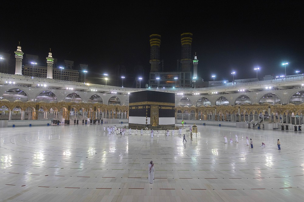 A small number of pilgrims circumambulate the Kaaba, the square structure in the Great Mosque, toward which believers turn when praying, in Mecca, Saudi Arabia, late Sunday, July 26, 2020. Anywhere from 1,000 to 10,000 pilgrims will be allowed to perform the annual hajj pilgrimage this year due to the coronavirus pandemic. (Saudi Ministry of Media via AP)