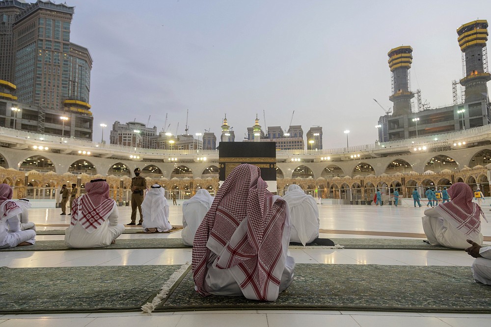Pilgrims pray around the Kaaba, the square structure in the Great Mosque, toward which believers turn when praying, in Mecca, Saudi Arabia, late Sunday, July 26, 2020. Anywhere from 1,000 to 10,000 pilgrims will be allowed to perform the annual hajj pilgrimage this year due to the virus pandemic. (Saudi Ministry of Media via AP)