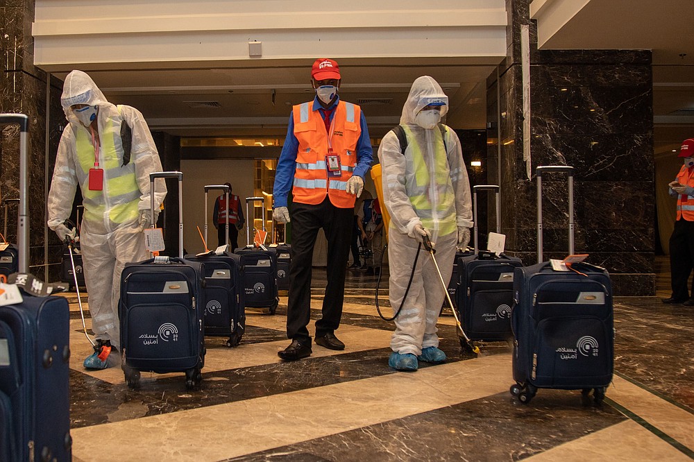 In this July 26, 2020, photo, the luggage of pilgrims is sanitized in a hotel lobby in Mecca ahead of the annual hajj pilgrimage. The Islamic pilgrimage has been dramatically downsized this year with only a few thousand residents of Saudi Arabia permitted to take part due to concerns over the coronavirus. (Saudi Ministry of Media)