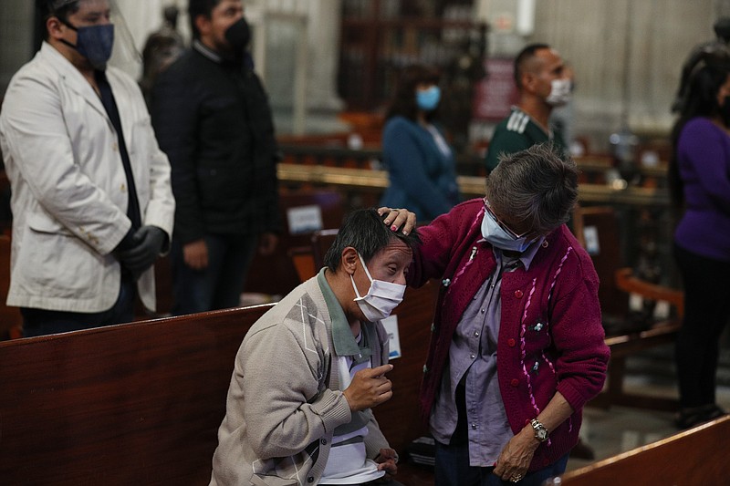 Alicia Eloina Contreras, 84, soothes her son, Jose Martin Castanon Contreras, 50, who has Down syndrome and has lost his senses of sight and hearing, during Catholic Mass on the first day Metropolitan Cathedral reopened for public services amid the ongoing coronavirus pandemic, in Mexico City. “He lives in his own world now,” said Contreras of her son, “but he is an angel of God.”
(AP/Rebecca Blackwell)
