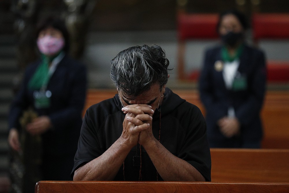A man prays during Catholic Mass, on the first day the Metropolitan Cathedral reopened for public services amidst the ongoing coronavirus pandemic, in Mexico City, Sunday, July 26, 2020. (AP Photo/Rebecca Blackwell)