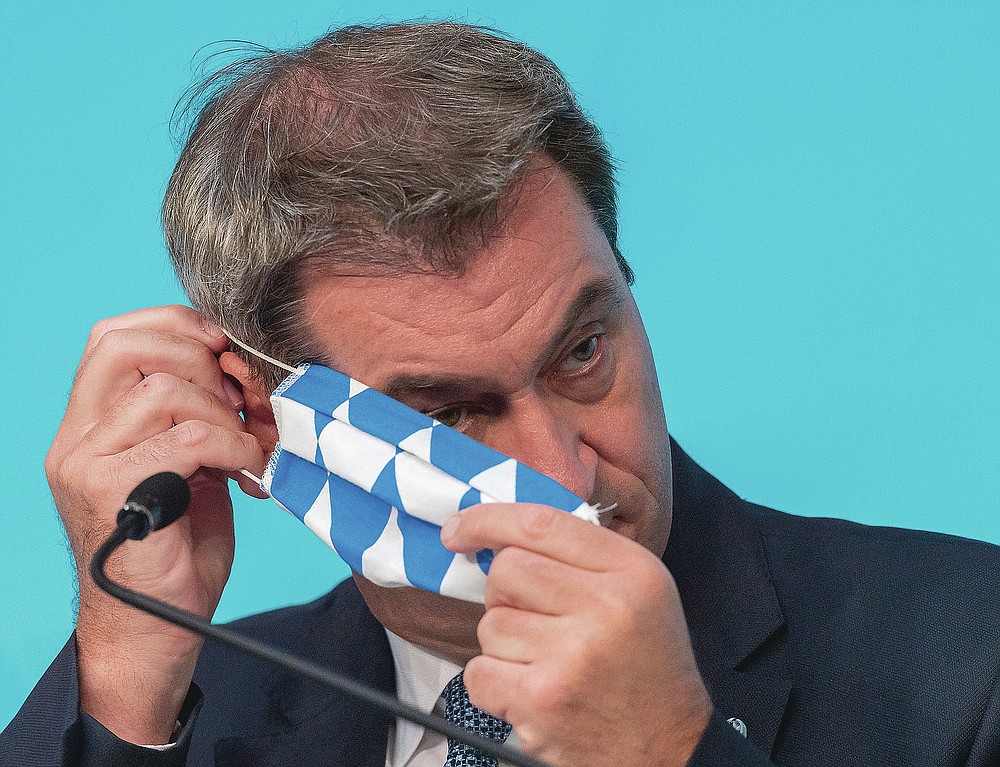 Markus Soeder, Prime Minister of German federal state Bavaria, takes part in a press conference on the coronavirus mass infection of harvest workers on vegetable farm in Mamming, in the Bavarian capital Munich, Germany, Monday, July 27, 2020. (Peter Kneffel/dpa via AP)