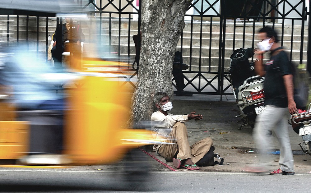 An Indian man wearing mask as a precaution against the coronavirus seeks alms at a street in Hyderabad, India, Monday, July 27, 2020. India is the third hardest-hit country by the pandemic in the world after the United States and Brazil. (AP Photo/Mahesh Kumar A.)