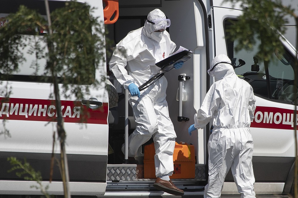 Medical workers wearing protective gear get out from an ambulance as they transport a patient suspected of having coronavirus, at a hospital in Kommunarka, outside Moscow, Russia, Tuesday, July 28, 2020. The number of new coronavirus cases in Moscow has been steadily rising since July 16, when city officials reported over 500 new infections. On July 28, Russia's capital registered at least 674 new infections. (AP Photo/Pavel Golovkin)