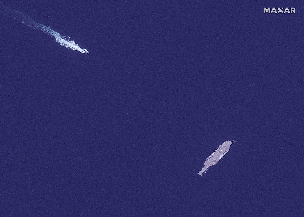 In this July 26, 2020, satellite photo provided on July 27, by Maxar Technologies, an Iranian fast boat, top left, approaches a mockup aircraft carrier built by Iran in the Strait of Hormuz. Satellite photographs released Monday, July 27, showed Iran has moved the aircraft carrier out to sea likely for naval drills amid heightened tensions between Tehran and the U.S. (Maxar Technologies via AP)