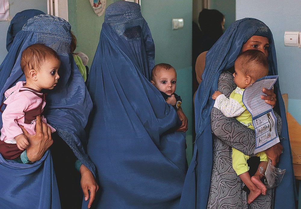 FILE - In this Aug. 26, 2019 photo, mothers hold their babies suffering from malnutrition as they wait at a UNICEF clinic in Jabal Saraj, north of Kabul, Afghanistan. In Afghanistan, severe childhood malnutrition spiked from 690,000 in January 2020 to 780,000 — a 13% increase, according to UNICEF. Food prices have risen by more than 15%, according to the World Food Program. (AP Photo/Rafiq Maqbool)