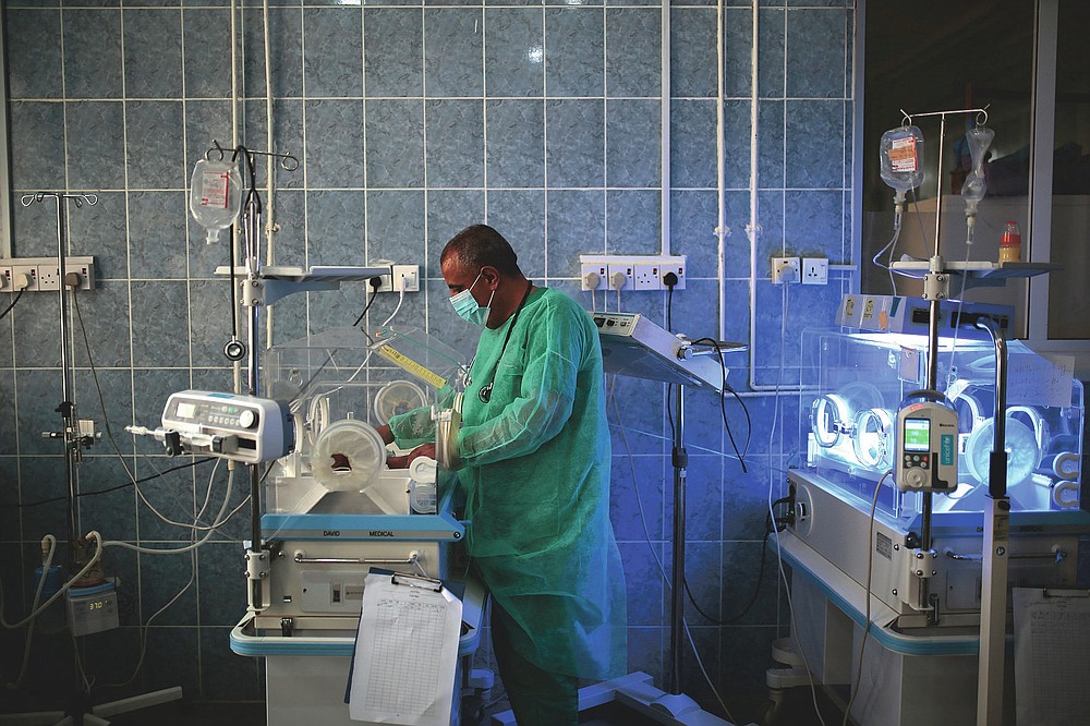 FILE - In this Saturday, June 27, 2020 file photo, a doctor checks a malnourished newborn baby inside an incubator at Al-Sabeen hospital in Sanaa, Yemen. Coronavirus restrictions on movement have blocked the distribution of aid, along with the stalling of salaries and price hikes. (AP Photo/Hani Mohammed)