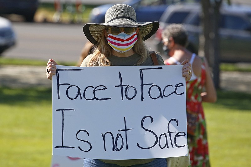 Kris Reddout, a 5th grade teacher, attends a Utah Safe Schools Mask-In urging the governor's leadership in school reopening during a rally Thursday, July 23, 2020, in Salt Lake City. Parents and teachers rallied at the Utah State Capitol Thursday morning to urge schools to enforce mask wearing and to implement other safety policies recommended by health officials as the state prepares to reopen classrooms this fall. (AP Photo/Rick Bowmer)
