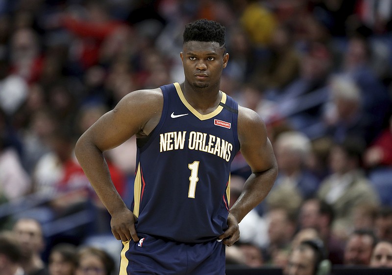 FILE - In this March 6, 2020, file photo, New Orleans Pelicans forward Zion Williamson walks onto the court during the second half of the team's NBA basketball game against the Miami Heat in New Orleans. The rookie sensation’s availability to play remained unclear as the season’s resumption in Lake Buena Vista, Florida, approached. He left the NBA’s so-called “bubble” setup on July 16 to attend to an unspecified family medical matter. A week later, the club had yet to provide an update on his possible return.  (AP Photo/Rusty Costanza, File)