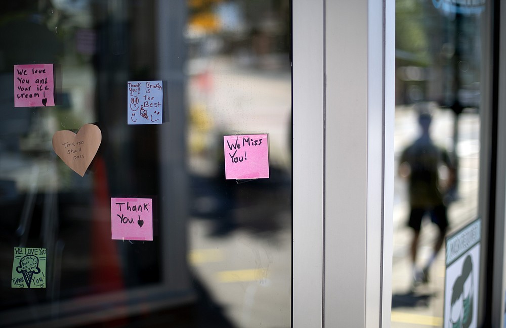 Notes from customers are posted on the window of one of two Brickley's Ice Cream shops which closed for the season after teenage workers were harassed by customers who refused to wear a mask or socially distance, in Wakefield, R.I., Wednesday, July 29, 2020. Disputes over masks and mask mandates are playing out at businesses, on public transportation and in public places across America and other nations. (AP Photo/David Goldman)