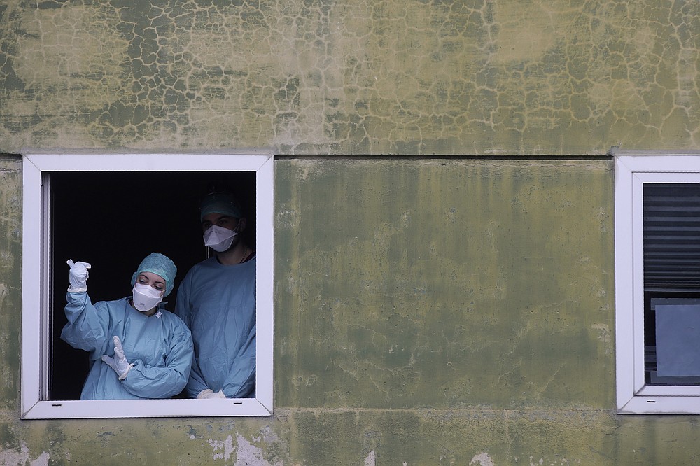 FILE - In this Thursday, March 12, 2020 file photo, medical staff in work at one of the emergency structures that were set up to ease procedures at the Brescia hospital, northern Italy. Amid the chaos of the pandemic’s early days, doctors who faced the first coronavirus onslaught reached across oceans and language barriers in an unprecedented effort to advise colleagues trying to save lives. (AP Photo/Luca Bruno)