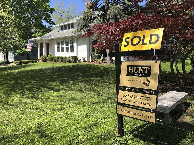 FILE - In this May 22, 2020 file photo a sold sign stands in front of a house in Brighton, N.Y. U.S. average rates on long-term mortgages declined this week, remaining near historic lows as the key 30-year loan slipped back below 3%. Mortgage buyer Freddie Mac reports the average rate on the 30-year home loan eased to 2.99% from 3.01% last week. (AP Photo/Ted Shaffrey, File)