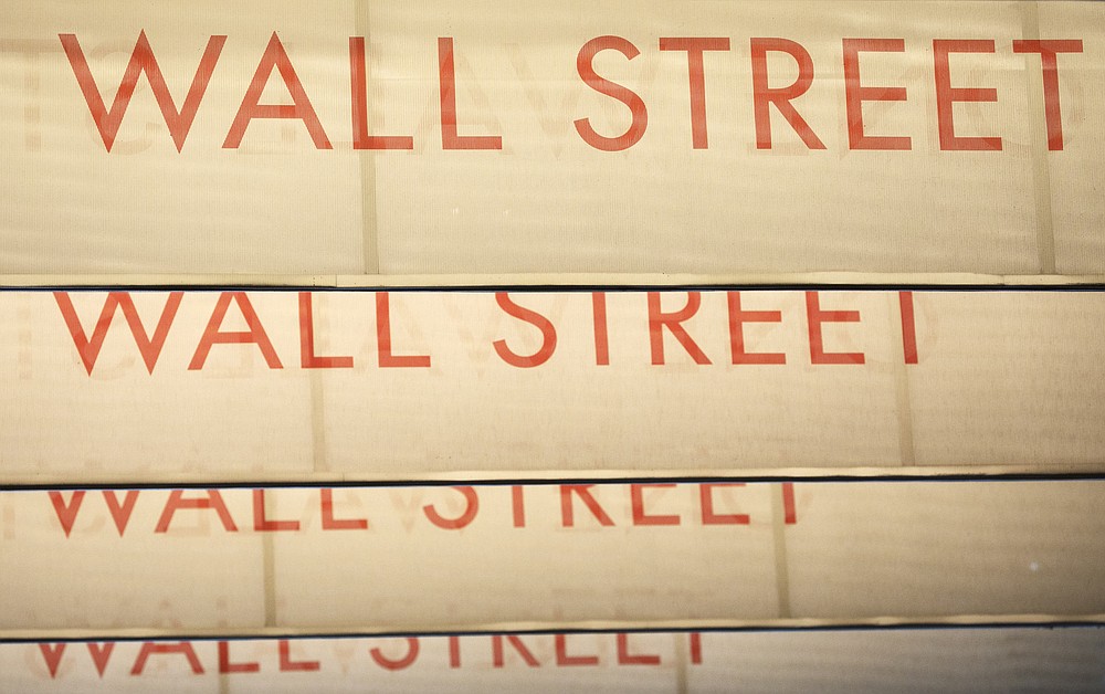 Signs for Wall Street are shown, Thursday, July 30, 2020, in New York. Stocks are falling on Wall Street Thursday after reports showed that layoffs are continuing at a stubborn pace and that the U.S. economy contracted at a nearly 33% annual rate in the spring. (AP Photo/Mark Lennihan)