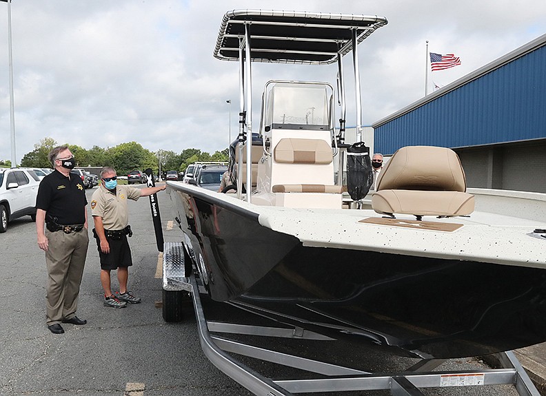 Garland County Sheriff Mike McCormick, left, and Cpl. Scott Hinojosa look over the department’s new marine patrol boat at Xpress Boats Thursday. - Photo by Richard Rasmussen of The Sentinel-Record
