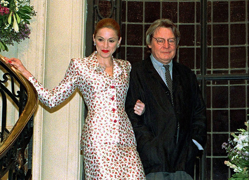 FILE - Actress-singer Madonna arrives for a news conference about the musical film "Evita" with British director Alan Parker in Buenos Aires on Feb.6, 1996. Parker, whose movies included “Bugsy Malone,” “Midnight Express” and “Evita,” has died at the age of 76. A statement from the director’s family says Parker died Friday in London after a long illness. (AP Photo/Daniel Muzio, File)