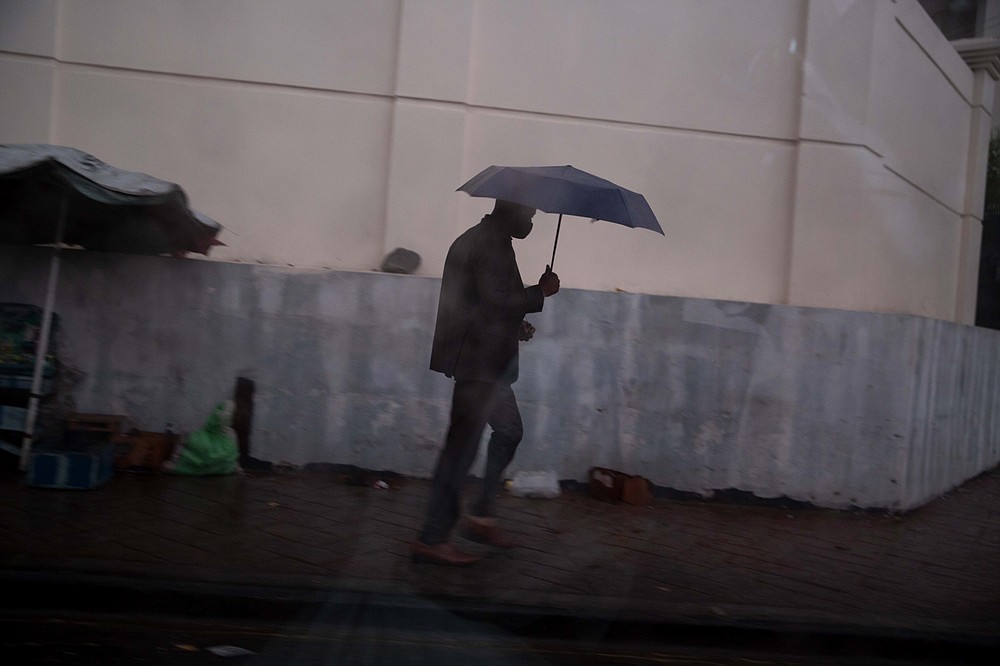 A man walks in the rain brought by the outer bands of Hurricane Isaias in the Petionville district of Port-au-Prince, Haiti, Friday, July 31, 2020. Isaias kept on a path early Friday toward the U.S. East Coast as it approached the Bahamas. (AP Photo/Dieu Nalio Chery)