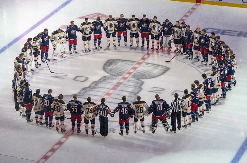 The Boston Bruins and the Columbus Blue Jackets stand together for the national anthems prior to Thursday's NHL exhibition game in Toronto. - Photo by Frank Gunn/The Canadian Press via The Associated Press story.lead_photo.caption