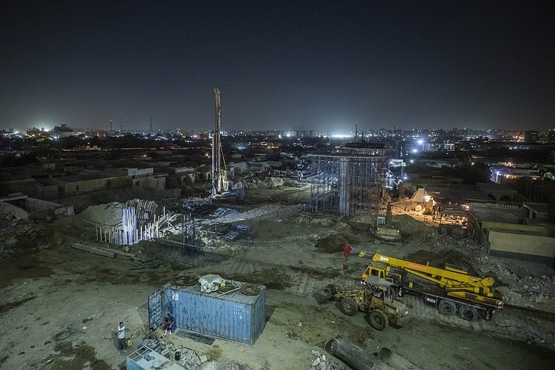 Construction work on a highway flyover in a portion cleared of graves in the City of Dead in Cairo, Egypt, on July 26. The overpass cuts through the Southern Cemetery, a sprawling necropolis that was first used 1,300 years ago and has been the burial place of nobles, holy men, scholars, poets and commoners ever since. Medieval guidebooks once traced itineraries for pilgrims to visit the graves of saint for blessings. Authorities say no ancient monuments were damaged in the construction, but preservationists are mourning the destruction to an urban fabric that was intact for centuries. - AP Photo/Nariman El-Mofty story.lead_photo.caption