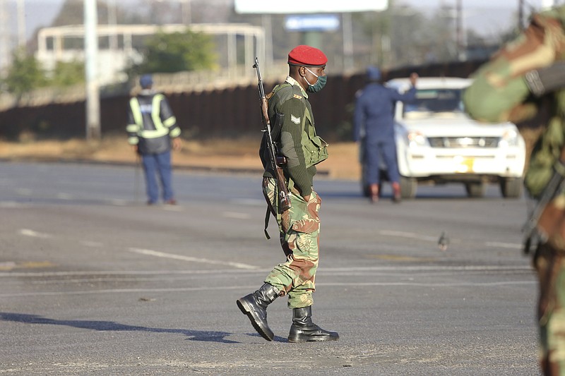 Armed soldiers patrol a street in Harare, Friday, July, 31, 2020. Zimbabwe's capital, Harare, was deserted Friday, as security agents vigorously enforced the country's lockdown amidst planned protests.Police and soldiers manned checkpoints and ordered people seeking to get into the city for work and other chores to return home. (AP Photo/Tsvangirayi Mukwazhi) story.lead_photo.caption