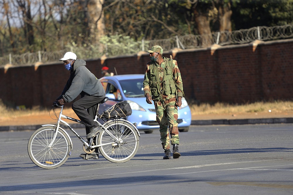 An armed soldier is seen on a street in Harare, Friday, July, 31, 2020. Zimbabwe's capital, Harare, was deserted Friday, as security agents vigorously enforced the country's lockdown amidst planned protests. Police and soldiers manned checkpoints and ordered people seeking to get into the city for work and other chores to return home. (AP Photo/Tsvangirayi Mukwazhi)