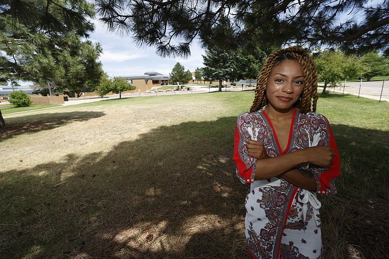 Tiera Brown stands outside Montbello High School in northeast Denver on June 22, 2020.  Brown, 28, who supported Denver schools’ decision to phase out officers, wonders if there would be more fellow Black students in her University of Denver law class if they had been treated with more understanding as young students. (AP Photo/David Zalubowski)